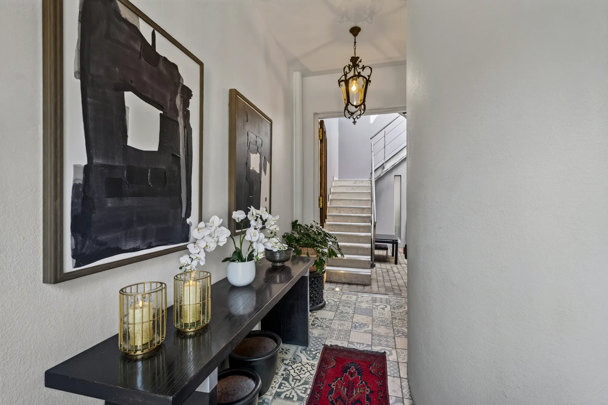 The Casa Dias entrance hall with orchids, artwork, and stairs beyond