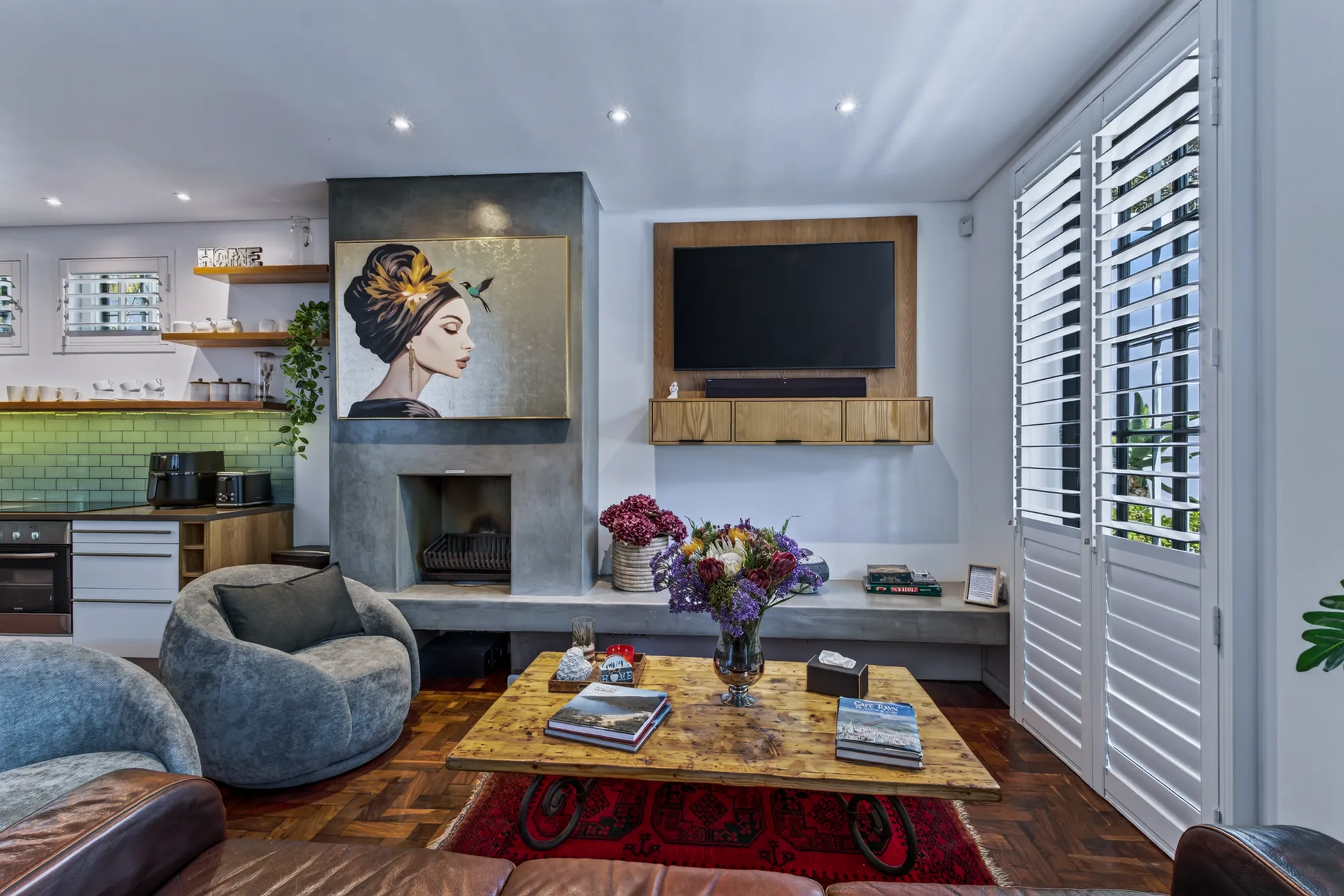 The living room at Casa Dias with a fireplace, television, and plantation shutters