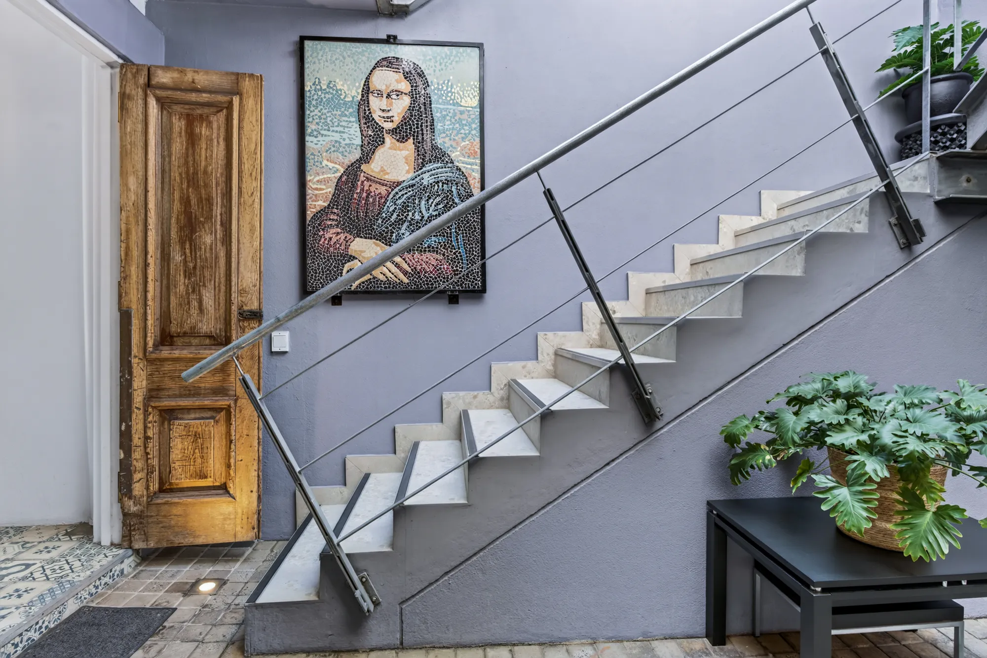 The staircase at Casa Dias beside a mosaic of the Mona Lisa